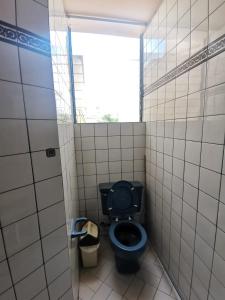 ein Bad mit einem blauen WC und einem Fenster in der Unterkunft ARTE Y CIENCIA in Lima