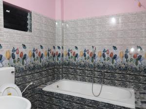 a bathroom with a bath tub and a toilet at SURYA VILLA GUEST HOUSE in Tajpur
