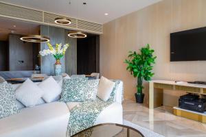 a living room with a white couch and a tv at FIVE Palm Jumeirah Residences - Mint Stay in Dubai