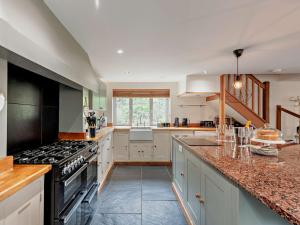 een keuken met witte kasten en een fornuis met oven bij 3 bed property in Bude 29125 in Thornbury