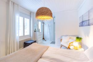 a white bedroom with a bed and a chair at Villa Aurinko Studio Apartment in Hanko in Hanko