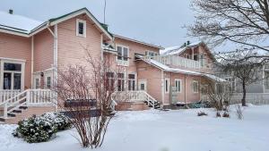une maison rose avec de la neige devant elle dans l'établissement Villa Aurinko Studio Apartment in Hanko, à Hanko