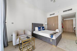 um quarto com uma cama, um sofá e uma cadeira em Modern Studio Apt in Meydan em Dubai