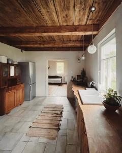 a kitchen with wooden ceilings and a kitchen with a sink at Bliska Wioska- Dom 