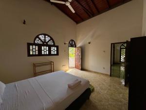 una camera con un letto bianco e due finestre di Sanka village a Habaraduwa Central