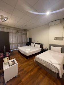 Habitación de hotel con 2 camas y mesa en Malaya Guest House en Budai