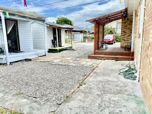 Un patio trasero con un patio y una casa. en A Cozy Cabin for two in Hamilton East near to CBD and Waikato Hospital, en Hamilton