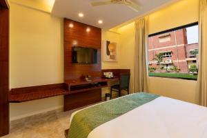 a bedroom with a bed and a desk and a television at Five Elements Hotels Mertiya Residency in Jodhpur