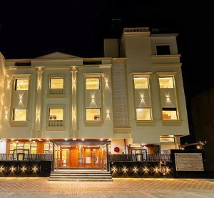 un grand bâtiment blanc avec ses lumières allumées dans l'établissement Five Elements Hotels Mertiya Residency, à Jodhpur