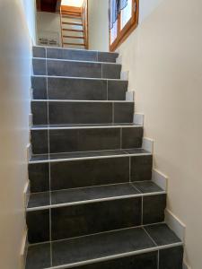a stairwell with black steps in a house at Joli T3 en Centre Village de Tallard in Tallard