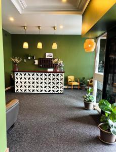 ein Wartezimmer mit grünen Wänden und Pflanzen und einer Theke in der Unterkunft Manjimup Hotel in Manjimup