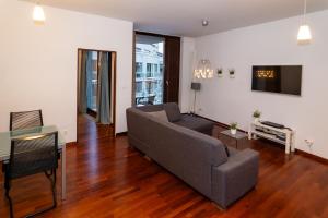 una sala de estar con un sofá y una mesa en Apartamenty Triton Park, en Varsovia
