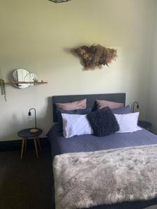 Un dormitorio con una cama con almohadas. en Moore St Cottage, en Ohakune