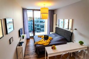 ein kleines Zimmer mit einem Bett und einem Laptop darauf in der Unterkunft Apartamenty Triton Park in Warschau