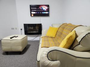 a living room with a couch and a tv at Full House on Crab Lane in Hednesford