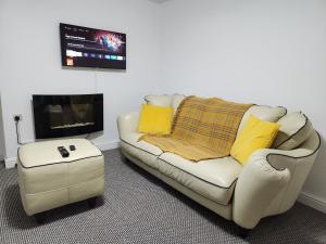 a living room with a white couch and a tv at Full House on Crab Lane in Hednesford