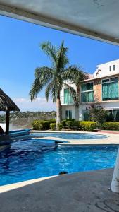 una piscina frente a una casa con palmeras en casa con hermosa vista al lago de tequesquitengo, en Tequesquitengo