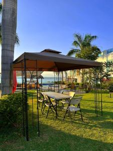 casa con hermosa vista al lago de tequesquitengo في تيكواسكيتامو: طاولة نزهة وكراسي تحت مظلة