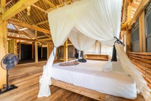 um quarto com uma cama com rede mosquiteira em Bale Bala Villa em Gili Meno