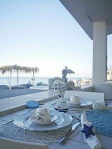 波拉聖喬凡尼的住宿－VILLA G&G CALABRIA，一张桌子,上面有盘子和餐具,靠近海滩
