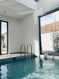 a swimming pool in a house with a window at Villa Neo with Jakuzi,indoor pool,sauna and floor heating in Fethiye