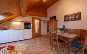 eine Küche und ein Esszimmer mit einem Holztisch in der Unterkunft Ferienwohnung „Rose“ in Wiesenfelden