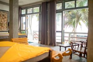 a bedroom with a bed and a large window at Oynise Beach Cabin in Galle