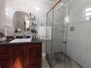 y baño con ducha, lavabo y espejo. en Cobertura em Cabo Frio, en Cabo Frío