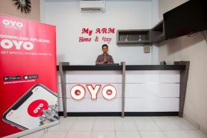 a man standing at a podium in a room at OYO 725 My Arm Home & Stay in Medan