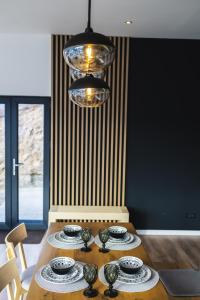 a dining room table with plates and a chandelier at Elysium Cabin in Muntele Rece