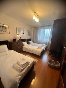 una camera d'albergo con due letti e una sedia di Apartament Diana - Traugutta Wrocław a Breslavia