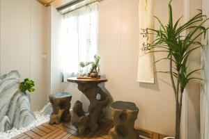 a living room with a table and a plant at Millennium Ancient Town River View B&B 2 in Shanghai