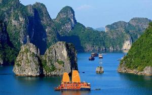 a group of boats in a river with mountains at Minasi Premium Hotel in Hanoi