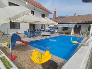 a swimming pool with a toy boat next to a house at Vila Jovana in Rogljevo