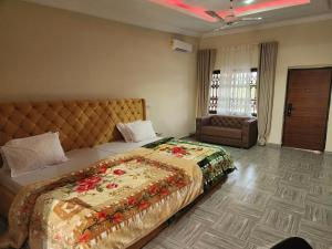Un dormitorio con una cama grande con flores. en C-VISION GUESTHOUSE, en Sefwi Bekwai