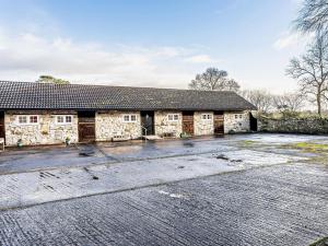 an old stone building with a driveway in front of it at 4 Bed in Wedmore 58843 in Theale