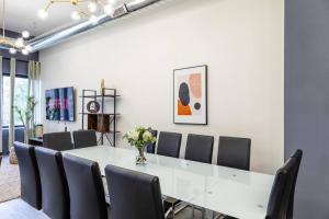 a conference room with a white table and chairs at Group-Friendly 6BR Luxury Suite in Prime South Loop Location with Optional Parking and Gym Access Near McCormick Place, Soldier Field and Grant Park in Chicago