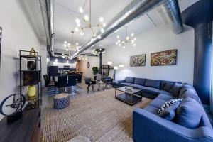a living room with a blue couch and a table at Group-Friendly 6BR Luxury Suite in Prime South Loop Location with Optional Parking and Gym Access Near McCormick Place, Soldier Field and Grant Park in Chicago