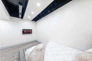 a white bedroom with a bed and a clock on the wall at Group-Friendly 6BR Luxury Suite in Prime South Loop Location with Optional Parking and Gym Access Near McCormick Place, Soldier Field and Grant Park in Chicago