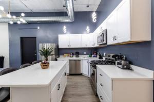 a kitchen with white cabinets and a blue wall at Group-Friendly 6BR Luxury Suite in Prime South Loop Location with Optional Parking and Gym Access Near McCormick Place, Soldier Field and Grant Park in Chicago
