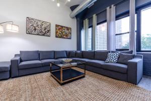 a living room with a blue couch and a table at Group-Friendly 6BR Luxury Suite in Prime South Loop Location with Optional Parking and Gym Access Near McCormick Place, Soldier Field and Grant Park in Chicago