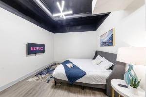 a small bedroom with a bed and a nightstand at Group-Friendly 6BR Luxury Suite in Prime South Loop Location with Optional Parking and Gym Access Near McCormick Place, Soldier Field and Grant Park in Chicago