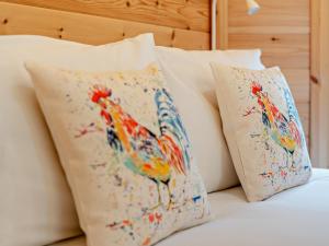 two pillows with a painting of a bird on a bed at 1 Bed in Libberton 91247 in Libberton