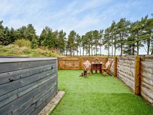 a backyard with a table and chairs and a fence at 1 Bed in Libberton 91247 in Libberton