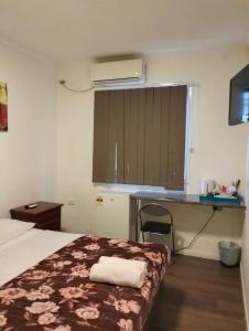 a hotel room with a bed and a desk with a window at cliffinn kangaroo point in Brisbane