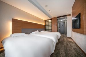 2 camas en una habitación de hotel con TV en Jeju Seongsan Golden View en Seogwipo