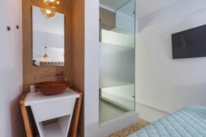 ein Bad mit einem Waschbecken und einem Spiegel in der Unterkunft Napoleon On The Beach in Paleokastritsa