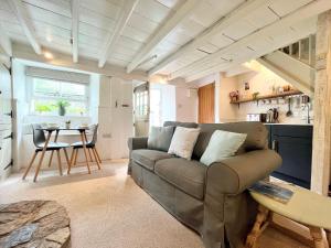 a living room with a couch and a table at Cosy Cottage Central Marazion with Parking in Marazion