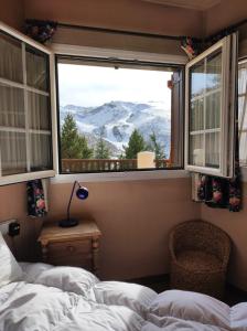 Schlafzimmer mit einem Bett und einem Fenster mit Bergblick in der Unterkunft Urb. Bugaboos - Sierra Nevada in Monachil