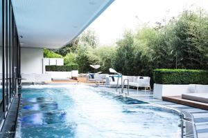 an outdoor swimming pool with white chairs and a swimming pool at Royal Savoy Hotel & Spa in Lausanne
